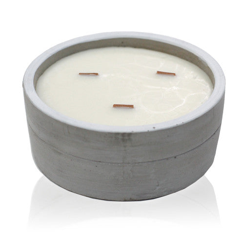 A concrete candle with a wooden wick, containing a white wax, Crackling wooden wicks in a round concrete pot with felt pads underneat.