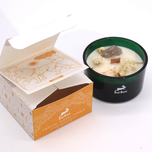 Candle in a green container with decorative packaging on a white background