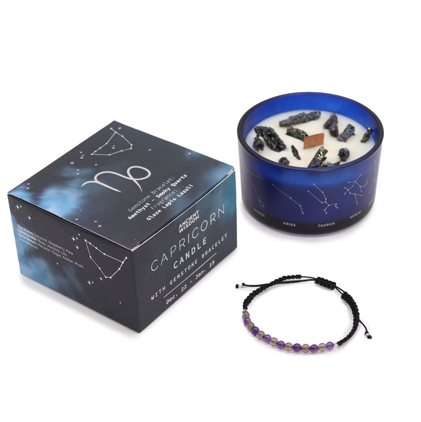 A set of a blue glass candle container with a Capricorn constellation design, filled with a white candle, and a gemstone bracelet beside it, with a black box packaging that has astrological symbols.