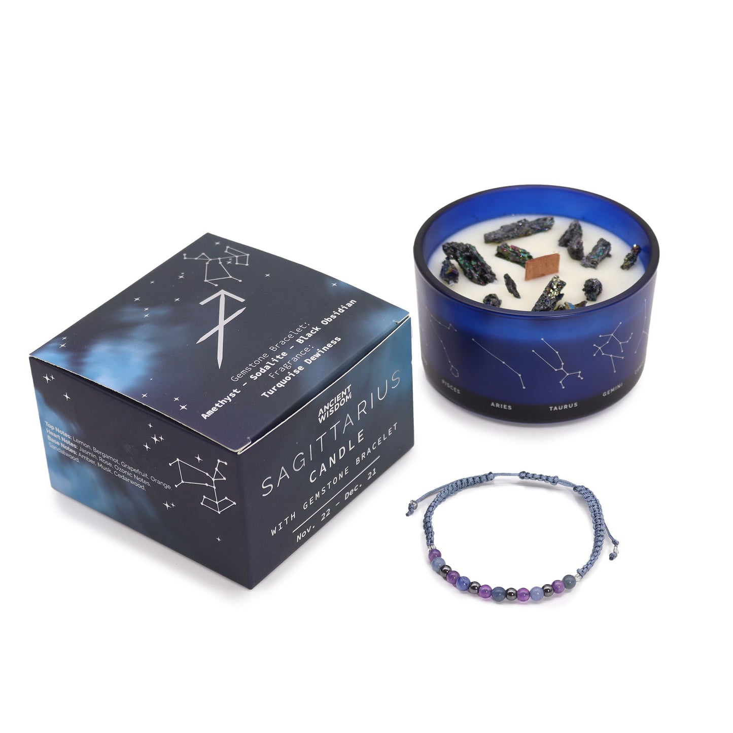 A Sagittarius-themed candle set including a blue container candle with a white wax surface, adorned with dark and light blue crystals, and a gemstone bracelet next to its packaging box with zodiac symbols.