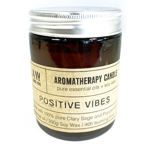Aromatherapy candle jar with label reading 'Positive Vibes' made with pure essential oils and soy wax, 40 hours burning time.