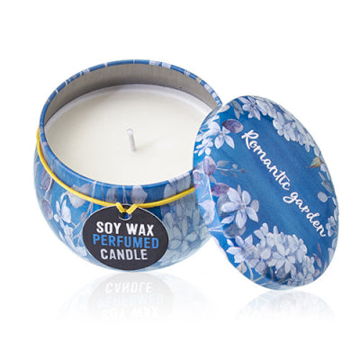Perfumed candle in a decorative tin with floral design on a white background