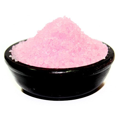 A small black bowl filled with pink simmering granules.