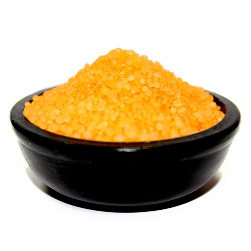 A black bowl filled with orange-coloured simmering granules.