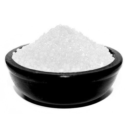 A bowl of white simmering granules designed to release a coconut scent when heated.