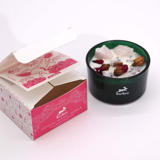 Black candle holder with decorative elements next to a pink box labeled 'Crystal Floral Candle' on a white background