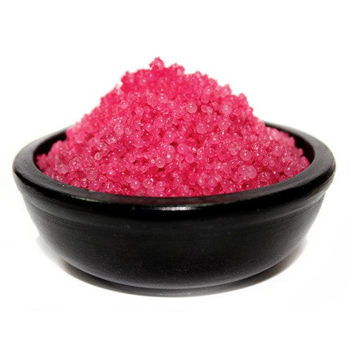 A black bowl filled with pink simmering granules 